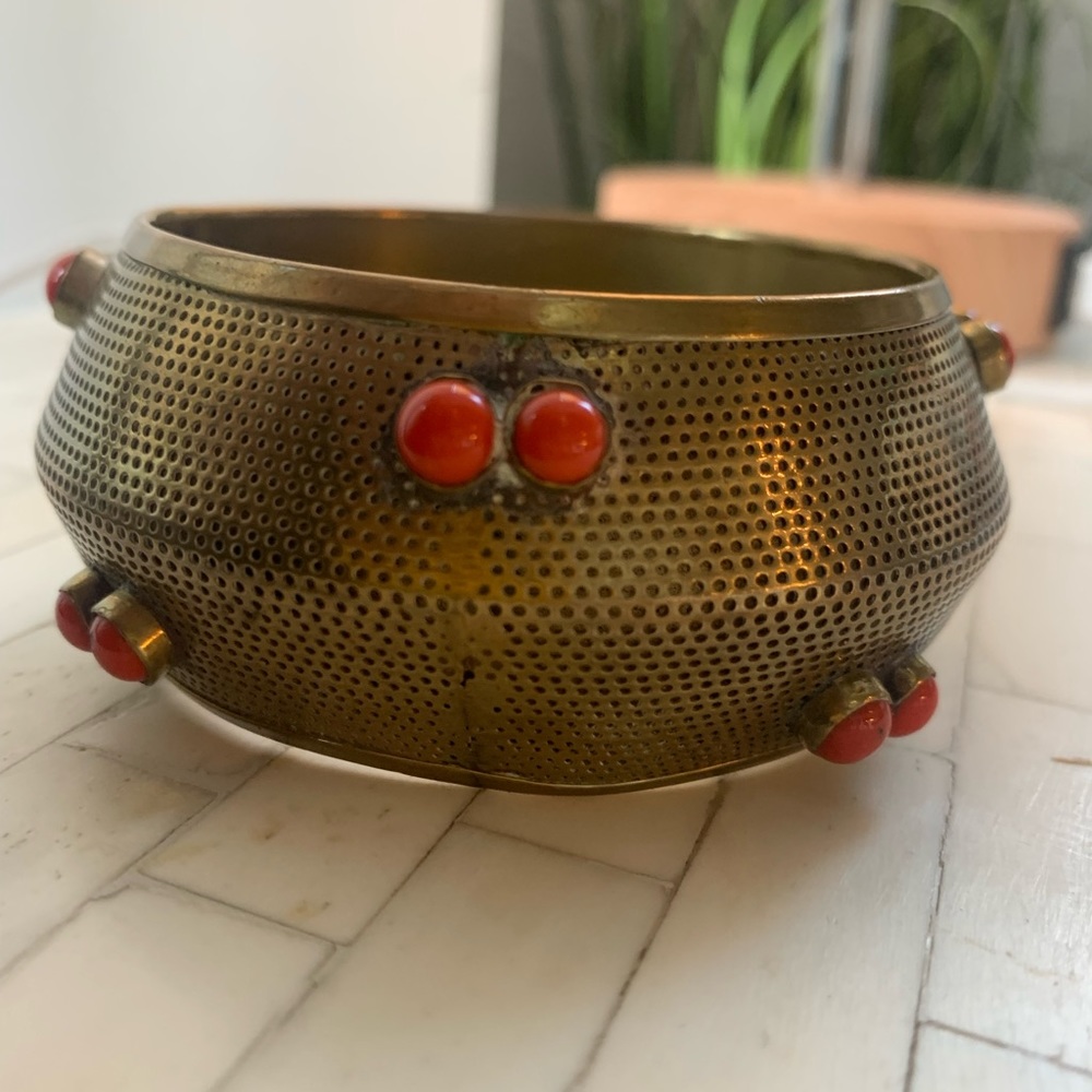 Vintage brass bracelet decorative pixel pattern w reddish orange tone stones.